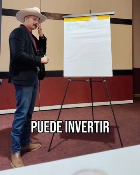 Marcos Ramirez dictando una clase junto a un rotafolio.